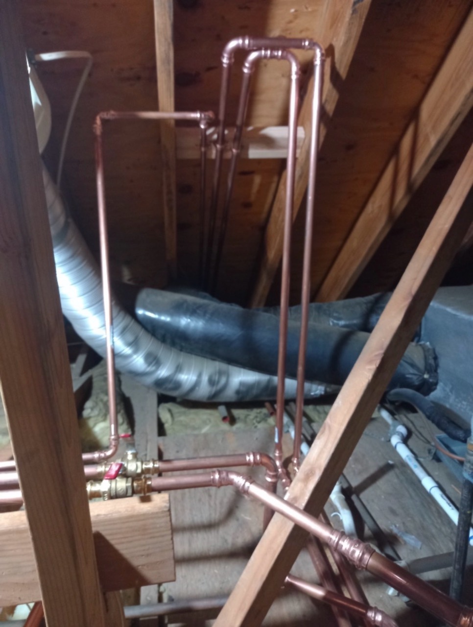 Copper repipe lines routed vertically through a tight attic