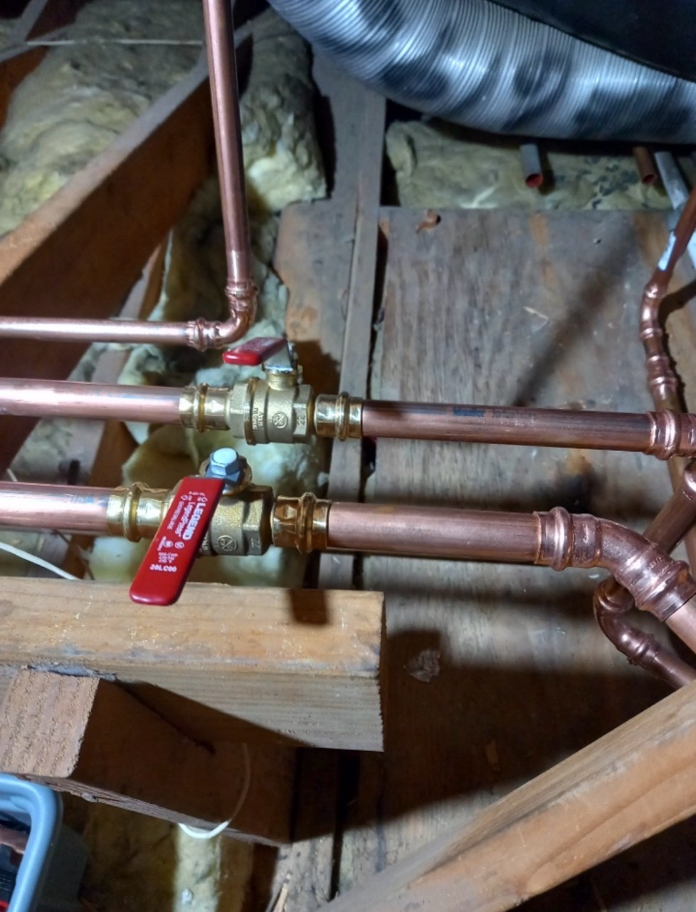 Close-up of copper repipe connections and brass shutoff valves