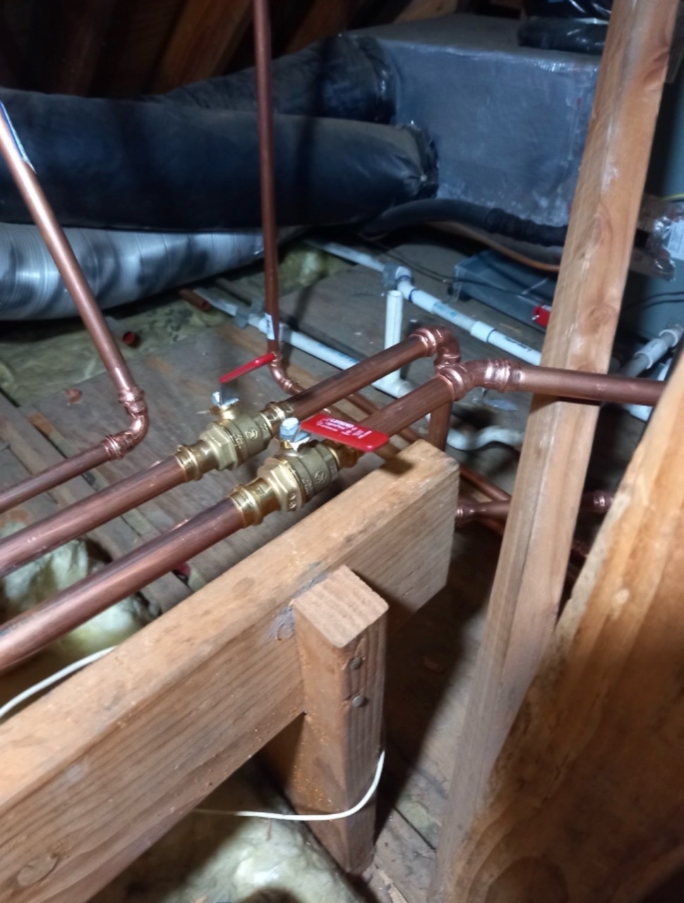 Copper supply lines and shutoff valves installed around attic framing